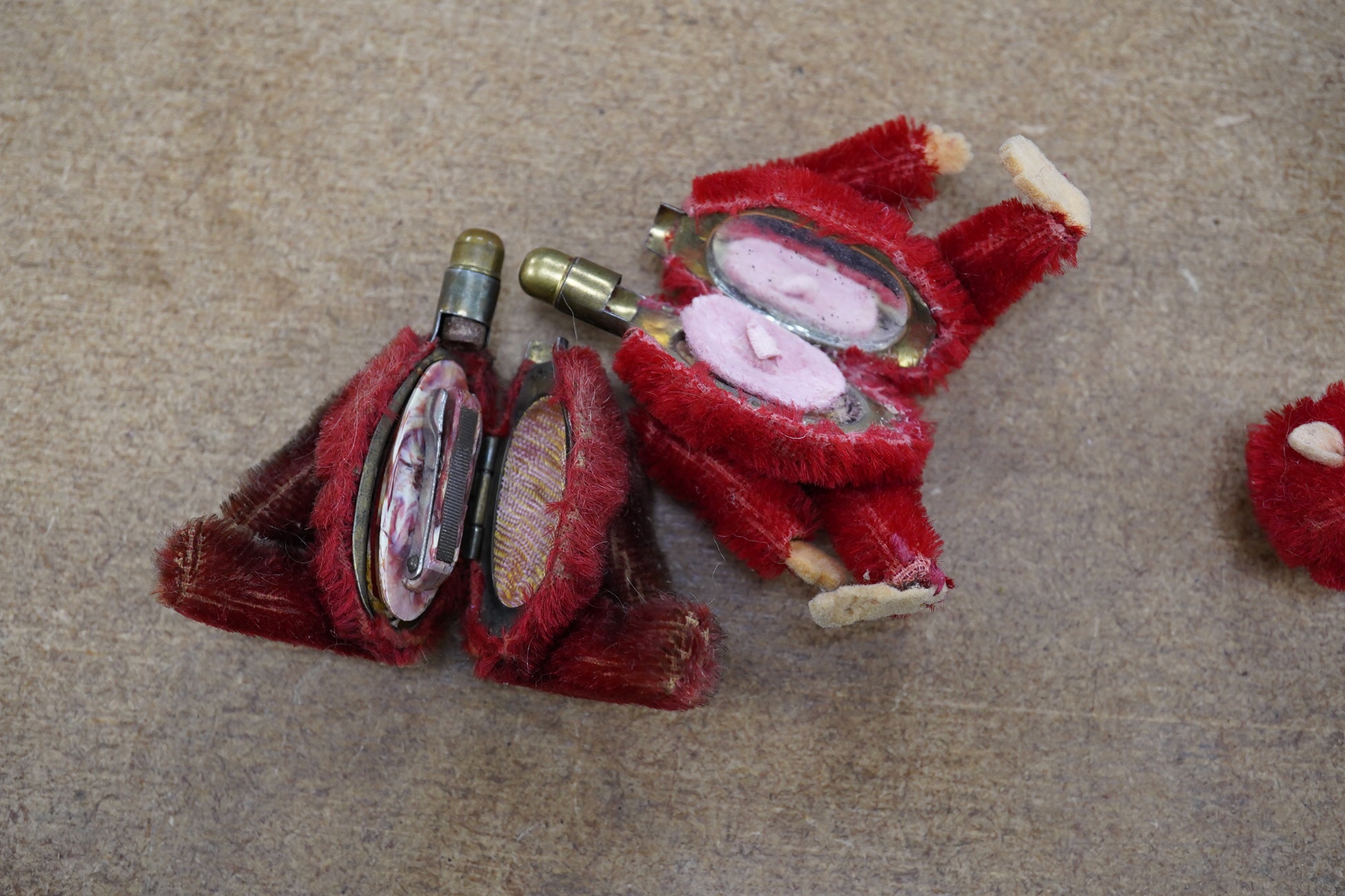 A red Schuco monkey compact with some slight wear to back of legs, otherwise in good unfaded condition, c1920, height 9cm, together with a Schuco Teddy manicure set in good condition, red mohair faded, height 9cm, c.1920